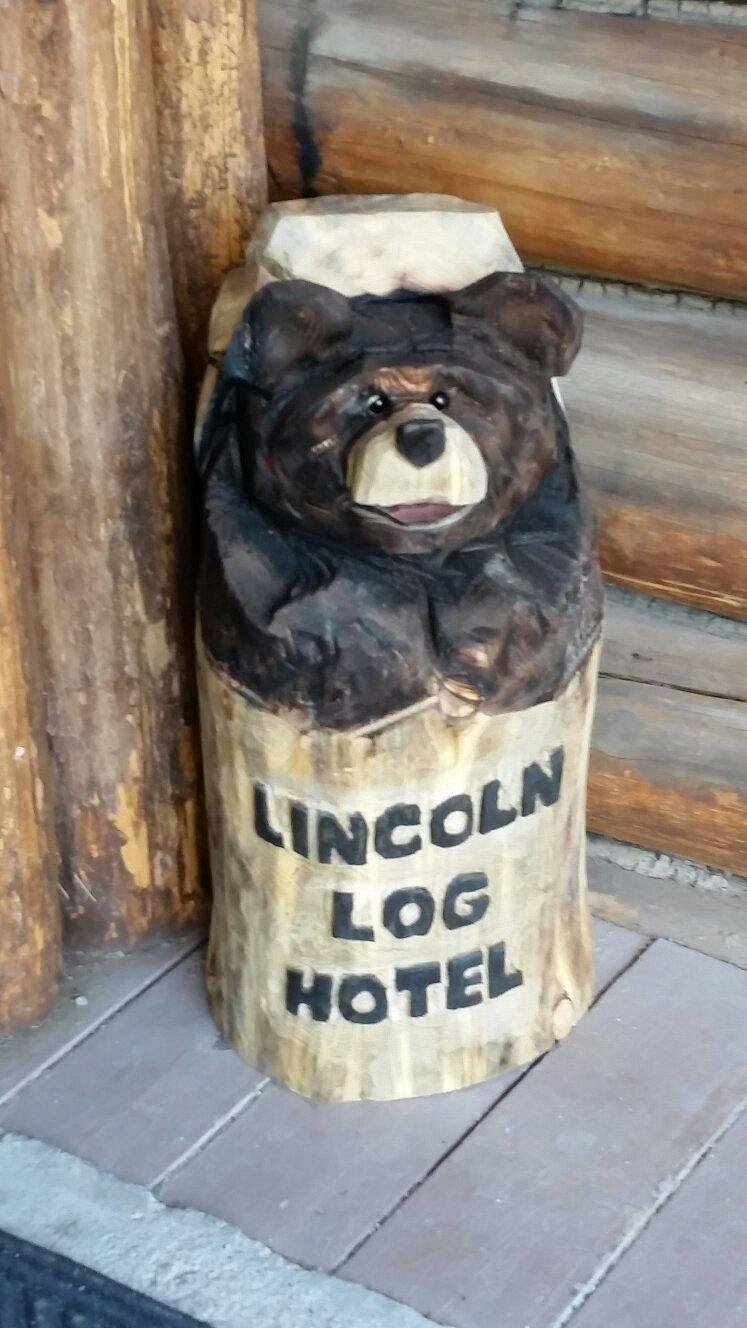 Carved bear mascot with Lincoln Log Hotel sign
