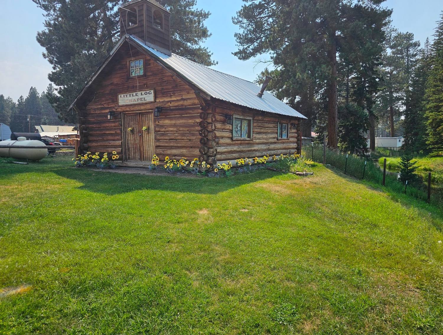 Historic Little Log Chapel with sunflowers in bloom